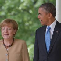 U.S. President Barack Obama and German Chancellor Angela Merkel walk through the Colonnade on their way to a joint press conference in the Rose Garden of the White House on Friday. Obama, Merkel vow broader Russian sanctions if Ukraine election derailed