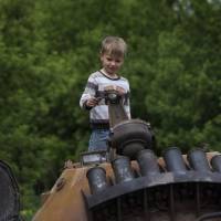 A boy stands atop a seized armored personnel carrier that was set alight during a fighting between pro-Russian militants and government troops in the village of Oktyabrskoye in eastern Ukraine on Wednesday. | AP