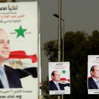 Campaign posters urge support for presidential candidate and former army chief Abdel-Fattah el-Sissi in Cairo on Sunday, a day ahead of presidential elections in Egypt. | AFP-JIJI