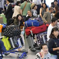Vacationers crowd the international arrival lobby of Narita airport Monday, the day before the end of Golden Week. | KYODO