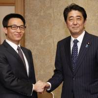 Vietnam’s Deputy Prime Minister Vu Duc Dam (left) greets Prime Minister Shinzo Abe as they meet in Tokyo on Thursday. Japan, Vietnam blame China for maritime tensions