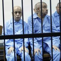 Former Prime Minister Baghdadi Mahmudi (left) and former Minister of Foreign Affairs Abdul Ati al-Obeidi in deposed leader Moammar Gadhafi\'s government sit behind bars during a hearing at a courtroom in Tripoli on April 27. | REUTERS