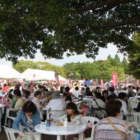Visitors enjoy local eateries\' fare at the food court in Yamashita Park at last year\'s Yokohama Central Town Festival | KYODO