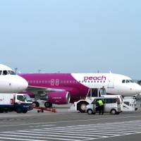 Peach Aviation Ltd.\'s Airbus A320 aircraft are pictured at Kansai International Airport, in Osaka Prefecture, in March 2012. | BLOOMBERG