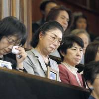 Members of a support group for families of victims of \"karoshi\" (death from overwork) watch as a bill passes the Lower House on Tuesday that would require the government to reduce instances of deadly workplace exhaustion. | KYODO