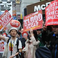 Fast-food workers and activists rally in Tokyo\'s Shibuya district Thursday as part of global campaign for higher pay at fast-food restaurants. Currently earning around &#165;800 per hour, employees at McDonald\'s and other chains are seeking nearly twice as much at &#165;1,500 per hour. | SATOKO KAWASAKI