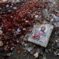 A bloodstained icon of Jesus lies among shattered glass near Donetsk airport in eastern Ukraine on Tuesday, after government forces clashed with rebel separatists, inflicting heavy losses in a ferocious firefight. Putin put in peril: Page 4 | REUTERS