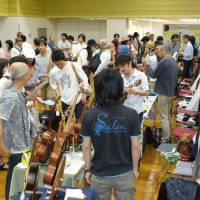Guitar heaven: Visitors to last year\'s Tokyo Guitar Craft Fes look peruse the artisan stalls. | KYODO