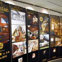 The work of Eiji Mitooka, who helped design the luxury Seven Stars train, is displayed at Takeo City Library on May 8 in Saga Prefecture. The Seven Stars train is operated by Kyushu Railway Co., which bills it as re-creating the golden age of travel. The train stops at spas and artisan centers in Kyushu. The exhibition runs through June 1. | KYODO