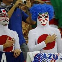 Japan\'s fans sing the national anthem Saturday before the start of their 2014 World Cup Group C soccer match against Cote d\'Ivoire at the Pernambuco arena in Recife, Brazil. | REUTERS