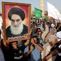 Armed Iraqi Shiite tribal fighters gathered in Baghdad’s Sadr City on Wednesday hold up a large portrait of the country’s top Shiite cleric, Grand Ayatollah Ali al-Sistani, during a rally against the Islamic State of Iraq and the Levant. Reclusive cleric takes charge in Iraq crisis