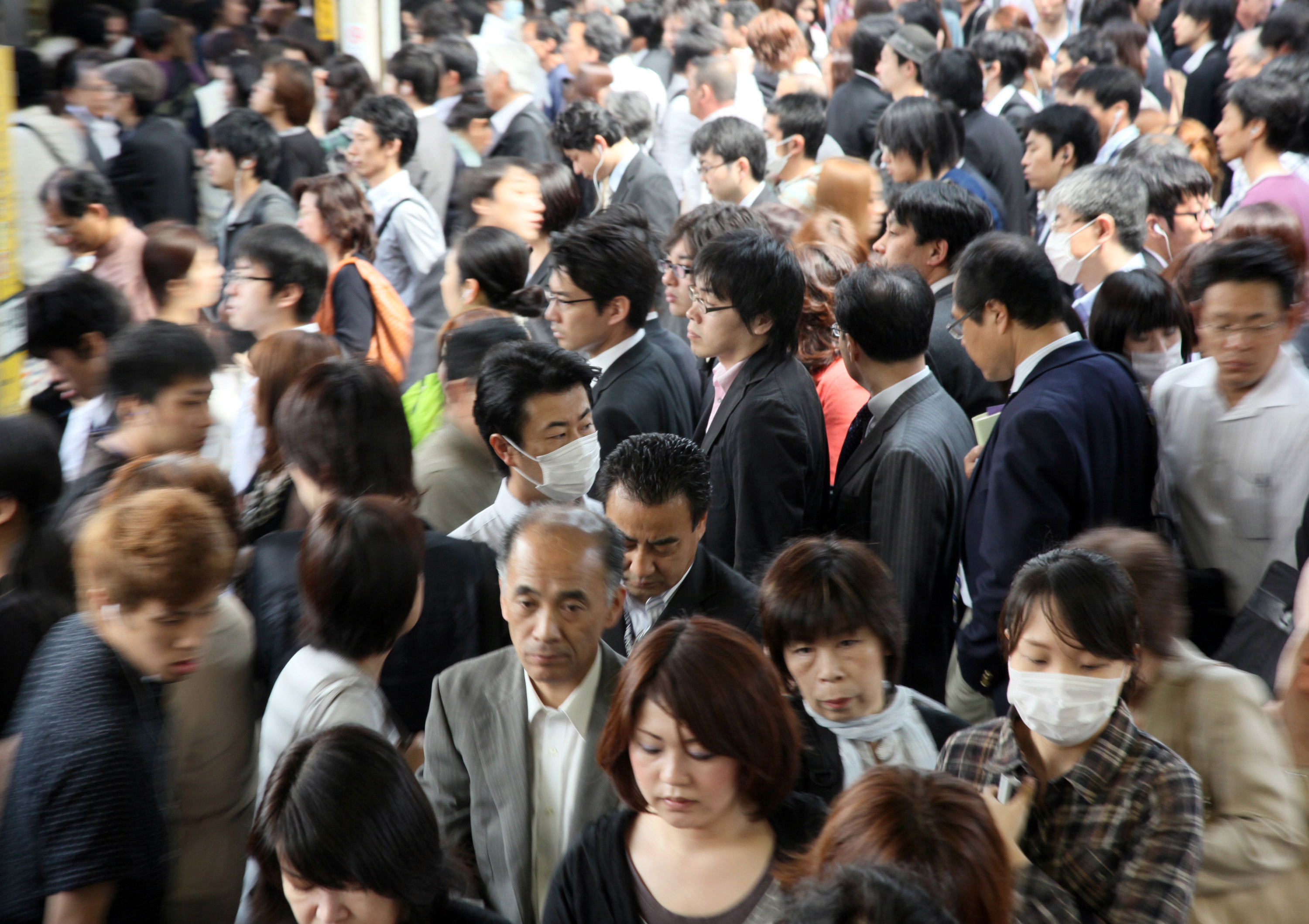 Commuters make their way slowly through a crowded train station in Tokyo in May 2011. | BLOOMBERG