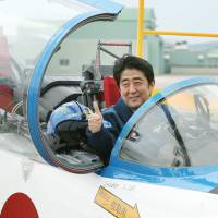 Prime Minister Shinzo Abe poses inside a T-4 training jet during a tour of the Air Self-Defense Force base in Higashimatsushima, Miyagi Prefecture, in May 2013. | AFP-JIJI