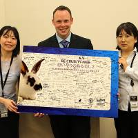 Cruelty-free covenant: Troy Seidle of Humane Society International, flanked by Sakiko Yamazaki (left) and Sachiko Azuma of HSI Japan, holds a board with signatures from those who have agreed to go \"cruelty-free.\" | HIDEHIKO SEKIGUCHI/HIS