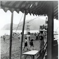 An image from the 1930s, of ladies and children on a beach near Kamakura with Enoshima island in the background. | ARCHIVE OF THE KAMAKURA CITY CENTRAL LIBRARY