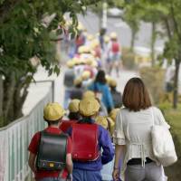 Children in Nikko, Tochigi Prefecture, make their way on Wednesday to Osawa Elementary School, which Yuki Yoshida attended prior to her murder in 2005. Students still walk to the school in groups for safety. | KYODO