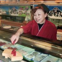 Chie Inamoto, manager and chef of an Isomaru outlet in Atami, Shizuoka Prefecture, serves sushi on April 30. | KYODO
