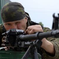 A pro-Russian fighter mans a position at a checkpoint just outside Slovyansk, in eastern Ukraine, on Monday. | AP