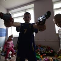 Children of families who fled fighting in the Ukrainian city of Slovyansk play with toy guns at a dormitory for displaced people in the town of Ilovaisk on Tuesday. Some residents of nearby Luhansk say they want to flee the fighting but have nowhere to go. | REUTERS