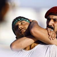 Shiite volunteers take part in a training session in the Iraqi shrine city of Najaf on Monday. They volunteered to protect holy sites in the event of an attack by Sunni militants from the Islamic State of Iraq and the Levant. | AFP-JIJI