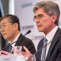 Shunichi Miyanaga, chief executive officer of Mitsubishi Heavy Industries, and Joe Kaeser, CEO of Siemens, hold a news conference in Paris on Tuesday to announce a joint bid for Alstom SA. | BLOOMBERG