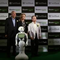 Former U.S. Secretary of State Colin Powell, now an external board member of Bloom Energy, appears in Tokyo on Tuesday with U.S. Ambassador Caroline Kennedy and SoftBank Corp. Chief Executive Masayoshi Son to launch Bloom Energy Server, a solid-oxide fuel cell that its manufacturer says produces clean energy. With them is SoftBank\'s Pepper robot. | REUTERS