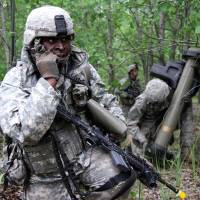 A U.S. soldier (left) takes part in a training exercise during the first phase of Saber Strike 2014, at Rukla military base in Lithuania, on June 14. Saber Strike, a NATO exercise, took place over multiple locations in Latvia, Lithuania and Estonia, and involved approximately 4,700 personnel from 10 countries from the U.S. and ex-Soviet Baltic states amid a spike in tensions with Moscow over the Ukraine crisis. | AFP-JIJI