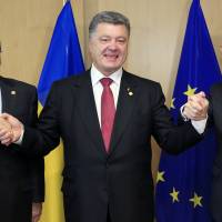 Ukrainian President Petro Poroshenko (center) poses with European Commission President Jose Manuel Barroso (left) and European Council President Herman Van Rompuy during an EU summit in Brussels on Friday after signing a trade and economic pact with the European Union, saying it may be the \"most important day\" for his country since it became independent from the Soviet Union in 1991. | AP