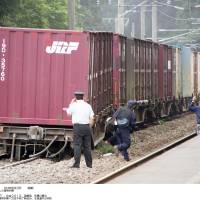 Railway maintenance workers check the site where two cars of a freighter train derailed on a section of the JR Esashi Line at Kikonai, southern Hokkaido, on Sunday morning. | KYODO