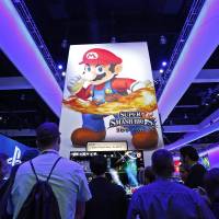 Gamers gather around a new Nintendo \"Super Smash Bros.\" game for Wii U at the 2014 Electronic Entertainment Expo, also known as E3, in Los Angeles on Tuesday. | REUTERS