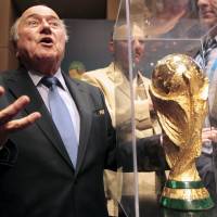 FIFA President Sepp Blatter gestures next to the World Cup trophy after a media conference in Sao Paulo on Thursday. The 2014 World Cup will be held in 12 cities in Brazil from June 12 to July 13. | REUTERS