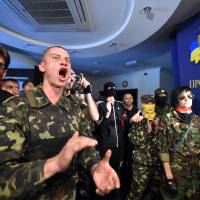 \"Maidan\" self-defense activists and activists of the Ukrainian ultra-nationalist Right Sector party shout slogans as they storm the Kiev City Prosecutors\' office on Friday. The protesters stormed the building demanding the city prosecutors\' resignation and a purge of prosecutors who took part in the repressions of the anti-government protests on Kiev\'s Independence Square. | AFP-JIJI