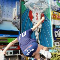 A man jumps from Ebisu Bridge into the Dotonbori Canal in central Osaka on Wednesday morning after Japan\'s national team washed out of the World Cup soccer tournament. | KYODO