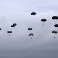 U.S. and Canadian paratroopers take part in Exercise Saber Strike in Adazi, Latvia, on Thursday. The drill involves 4,700 soldiers from 10 countries and is taking place also in Lithuania and Estonia. The three Baltic states border Russia. | REUTERS