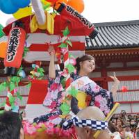 Osaka\'s first summer festival of the year: An Aizen Festival contestant entertains the crowds as she is paraded through the streets on a palanquin. | ADAM PASION