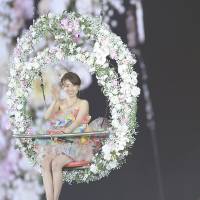 Yuko Oshima, 25, one of the most popular members of the all-girl idol group AKB48, waves to about 70,000 fans who came to see her perform in her last concert as an AKB member at Ajinomoto Stadium, in Chofu, western Tokyo, on Sunday. On Saturday, at the same stadium, hundreds of thousands of fans voted in an annual event to choose their favorite member. This year, Mayu Watanabe, 20, won the accolade for the first time with 159,854 votes. | KYODO