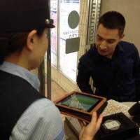 An official speaks to a foreign tourist at a Keikyu Line station. | KEIKYU CORP.