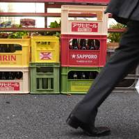 Cases of beer by brewer Kirin Holdings Co. and other makers are seen outside a store in Tokyo on Thursday. | REUTERS