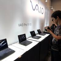 Members of the media look at Vaio Corp. Pro 11/13 laptop computers during a news conference in Tokyo on Tuesday. Sony Corp. has sold its PC division, which produces notebooks under the Vaio brand, to buyout firm Japan Industrial Partners Inc. | BLOOMBERG