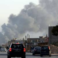 Smoke billows from an area near Tripoli\'s international airport during fighting between rival factions on Thursday. The United States evacuated its embassy staff under air cover from Libya on Saturday because they faced a \"real risk\" from the fierce fighting around the airport, Secretary of State John Kerry said. | AFP-JIJI