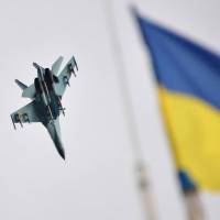 An air force fighter jet flies over the headquarters of the Ukrainian forces near Izyum in the northeast Tuesday. | AFP