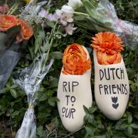 A message of sympathy for victims of the Malaysia Airlines Flight MH17 disaster is written on a wooden \"klomp,\" traditional footwear that was worn by Dutch farmers, placed together with a bouquet of flowers in front of the Netherlands Embassy in Washington on Monday. | AP