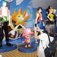 Visitors take pictures of characters from the popular Japanese manga series \"One Piece\" at an exhibition at the War Memorial of Korea on Saturday in Seoul. | KYODO