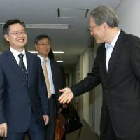 Hwang Joon-kook (left), South Korea\'s special representative for Korean Peninsula peace and security affairs, is greeted by Junichi Ihara, director general for Asian and Oceanic affairs, in Tokyo on Wednesday. | AP