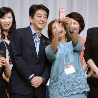 Prime Minister Shinzo Abe poses with participants at the 19th International Conference for Women in Business in Tokyo on Sunday. | KYODO