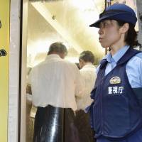 A Metropolitan Police Department officer guards the entrance to a \"dappo\" herb shop during an inspection Thursday in Shinjuku Ward\'s Kabukicho entertainment district. | KYODO