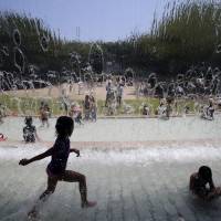 Children dip in a fountain at a park in Tokyo as soaring mercury across much of the nation prompted the Meteorological Agency to issue heat wave advisories Saturday for 41 of Japan\'s 47 prefectures. | AP