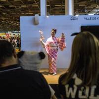 A Japanese woman dressed in a kimono performs a Japanese dance to promote the city of Kyoto at the 15th edition of the \"Japan Expo\" exhibition devoted to Japanese culture and entertainment Tuesday in Villepinte, a Paris suburb. The event, which runs until Sunday, promotes Japanese culture, including manga, anime and video games.   AFP-JIJI | REUTERS