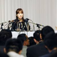 Assisted by lawyer Hideo Miki, Riken cytologist Haruko Obokata attends a news conference in April at a hotel in the city of Osaka. | KYODO