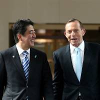 Prime Minister Shinzo Abe walks with Australian counterpart Tony Abbott after he addressed a joint sitting at Parliament House in Canberra on Tuesday. | REUTERS